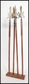 A medieval mahogany and brass stand with 4 axes, each with shaped heads on tall poles.