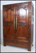 An 18th century French oak armoire - wardrobe being highly carved with beautiful brass fittings.