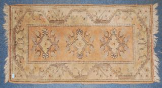 An Iranian - Afghan rug of beige colours with central medallions and tassled ends.