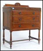 An Edwardian oak sideboard buffet of smaller proportions having a carved central panel back above