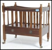 A 20th Century mahogany Canterbury - magazine stand with drawer below being raised on turned legs