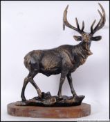A large cast iron vintage style figure of a Stag on a wooden podium. 37cm long.