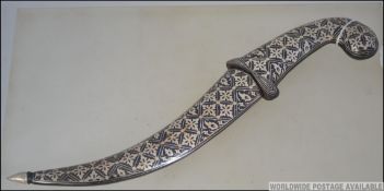 An arabic silver plated Persian dagger having geometric design complete with scabbard.