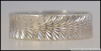 A 1970's 9ct white gold band ring being engine turned, hallmarked for London 1973. Weight 3.