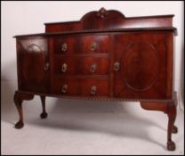 An Edwardian mahogany sideboard raised on ball and claw feet with a series of cupboards and drawers.