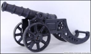 A large vintage style cast iron desk Cannon on wheels. 44cm long.