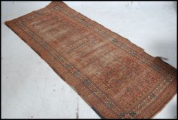 An early 20th century handwoven Bokhara rug set with red ground having multiple medallions to the