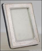 A silver hallmarked miniature picture frame with velour easel backed.