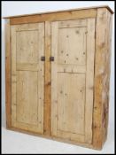 A large Victorian country pine housekeepers cupboard having plinth base with twin full length panel
