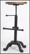 A vintage cast - wrought iron Industrial stool with foot rest having a later wooden carved seat of