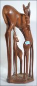 A large 20th century carved wooden figurine group of a deer and its young. Measures 63cms tall.