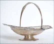 An Edwardian silver hallmarked large Bon Bon dish with swing handle and fret pierced borders.