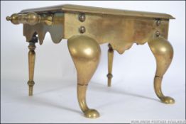 A 19th century brass footman raised on cabriole legs with broad shoulders and pad feet with fitted