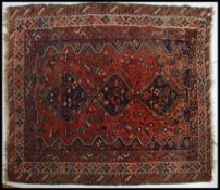 An early 20th century Persian handwoven rug having 3 central joinied medallions raised on ochre