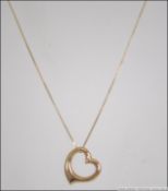 A ladies 9ct gold / 375 marked heart shaped pendant and fine necklace chain with c-shaped clasp