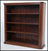 A Victorian mahogany open window bookcase with shaped sides and plinth base and top having fixed
