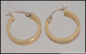 A pair of 14ct gold creole hoop earrings having greek key inspired design.
