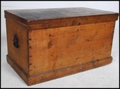 A Victorian pine blanket box having plinth base with cast iron ebonised carry handles with hinged