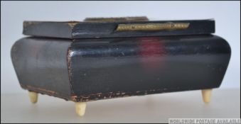 A bone inlaid panel top musical cigarette case having pictorial centre dating to the mid 20th