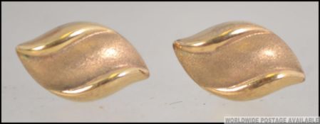 A pair of 9ct marked ladies gold earrings in the form of leaves having post backs.