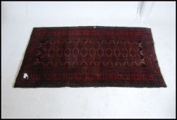 An early 20th century Persian handwoven Bokhora rug having central multiple medallions raised on