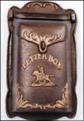 A vintage style, 20th century cast iron letter box displaying an image of a man riding a Horse.