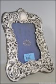 A silver hallmarked rococo in relief easel picture frame.