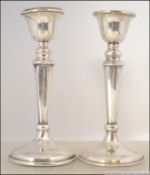 2 silver hallmarked candlesticks, each with terraced bases having single sconces.