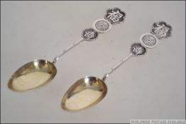 A pair of Chinese silver spoons with roundel character marks to the stems having oval bowls.