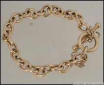 A 9ct gold chain linked bracelet with bar and hoop clasp hallmarked 375. Complete with safety chain.