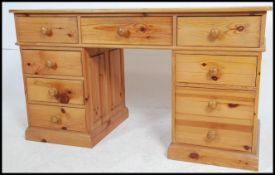 A contemporary antique style pine twin pedestal desk raised on a plinth base with drawers above.