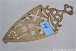 A brass trivet cast with masonic symbols dating to the late 19th century. Measures 21cms long.