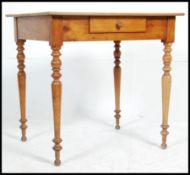 A 19th century French country fruitwood writing table desk being raised on turned legs with flared