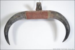 A pair of vintage 20th century taxidermy bull horns mounted with a central pad. Measures 52cm wide.