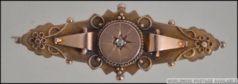 A late Victorian 9ct gold / 375 Chester hallmarked bar and filigree brooch with inset central