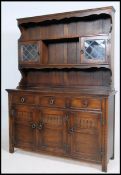 A Jaycee Jacobean oak dresser having cupboards and short drawers to the base with upright plate