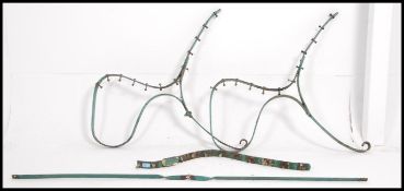 An early 20th century wrought iron pair of painted bench ends in green paint finish.