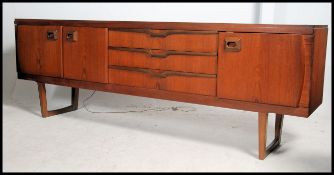 A 1970's retro teak wood Danish influence sideboard raised on angled legs with return stretchers.