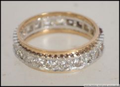 A 9ct gold eternity ring, with a silver / white metal central band. Ring size P.5. Total weight 5g.