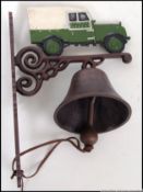 A cast iron bell which features a classic two door green Land Rover above it. 31cm long.