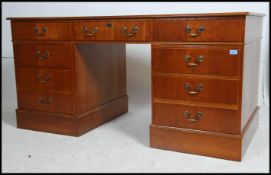 A Georgian style large mahogany twin pedestal office desk with green leather gilt tooled top having