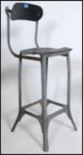 A mid century factory Industrial machinists stool - chair raised on a shaped metal frame with foot