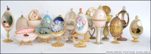 A collection of hand painted goose eggs in the Faberge style each being raised on gilt plinths.