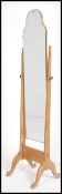 A antique pine style shaped Cheval swivel mirror raised on shaped supports