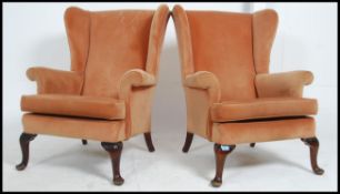A vintage mid century vintage Parker Knoll armchairs raised on cabriole legs with pad feet having