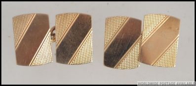 A pair of 9ct gold gentlemans cufflinks being engine turned with banded and stripe concentric