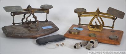 Two early 20th century brass and oak postal scales with weights together with 2 whistles,