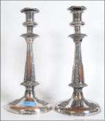 A pair of early 20th century silver plated copper candlesticks having rococo embellishments with