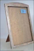An Edwardian silver hallmarked picture frame with oak back and easel stand.