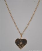 A 9ct gold heart pendant necklace and chain being hoop linked.